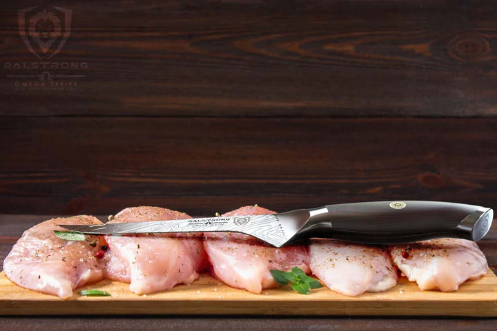 Dalstrong omega series 6 inch straight boning knife with five cuts of chicken meat.