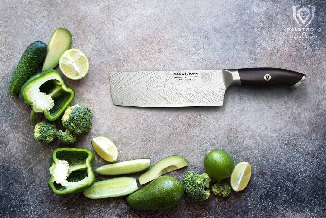 Dalstrong omega series 7 inch nakiri knife with slices of avocado, lime, bell peppers and broccoli.