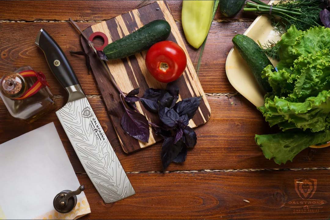 Dalstrong omega series 7 inch nakiri knife with vegetables at the side.