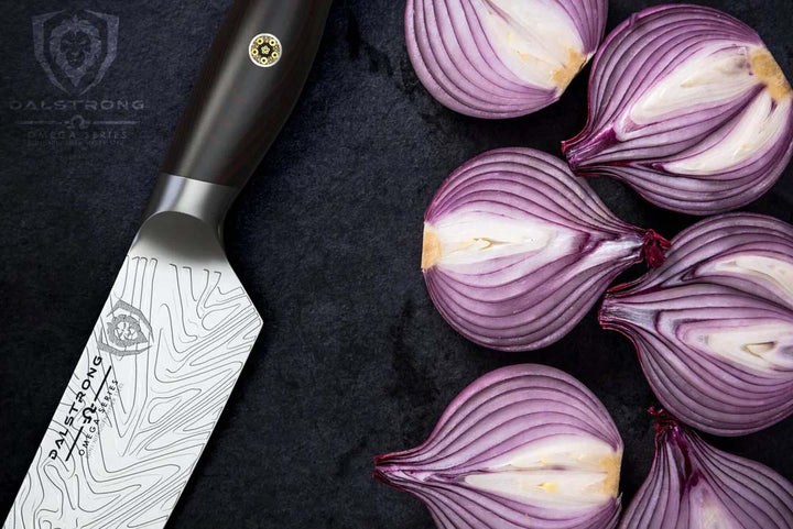 Dalstrong omega series 7 inch santoku knife beside onions sliced in half.