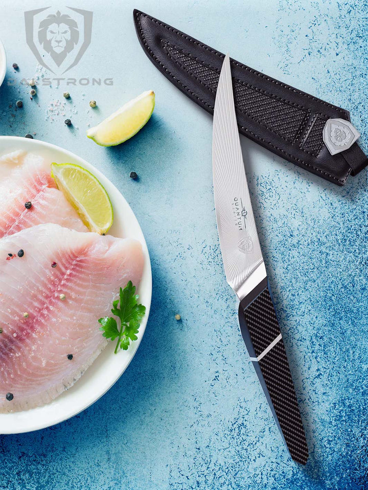 Dalstrong quantum 1 series 6.5 inch curved boning knife with dragon skin handle and two fillets of fish on a plate.