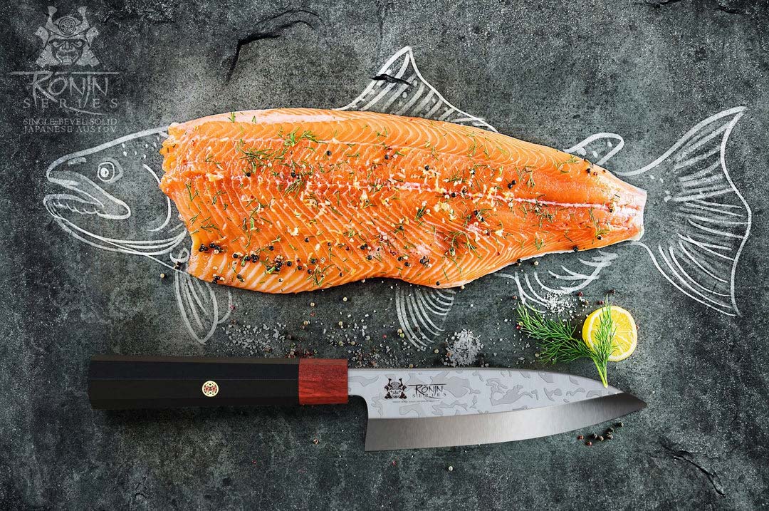 Dalstrong ronin series 6 inch deba knife with black handle and a whole fillet of salmon.