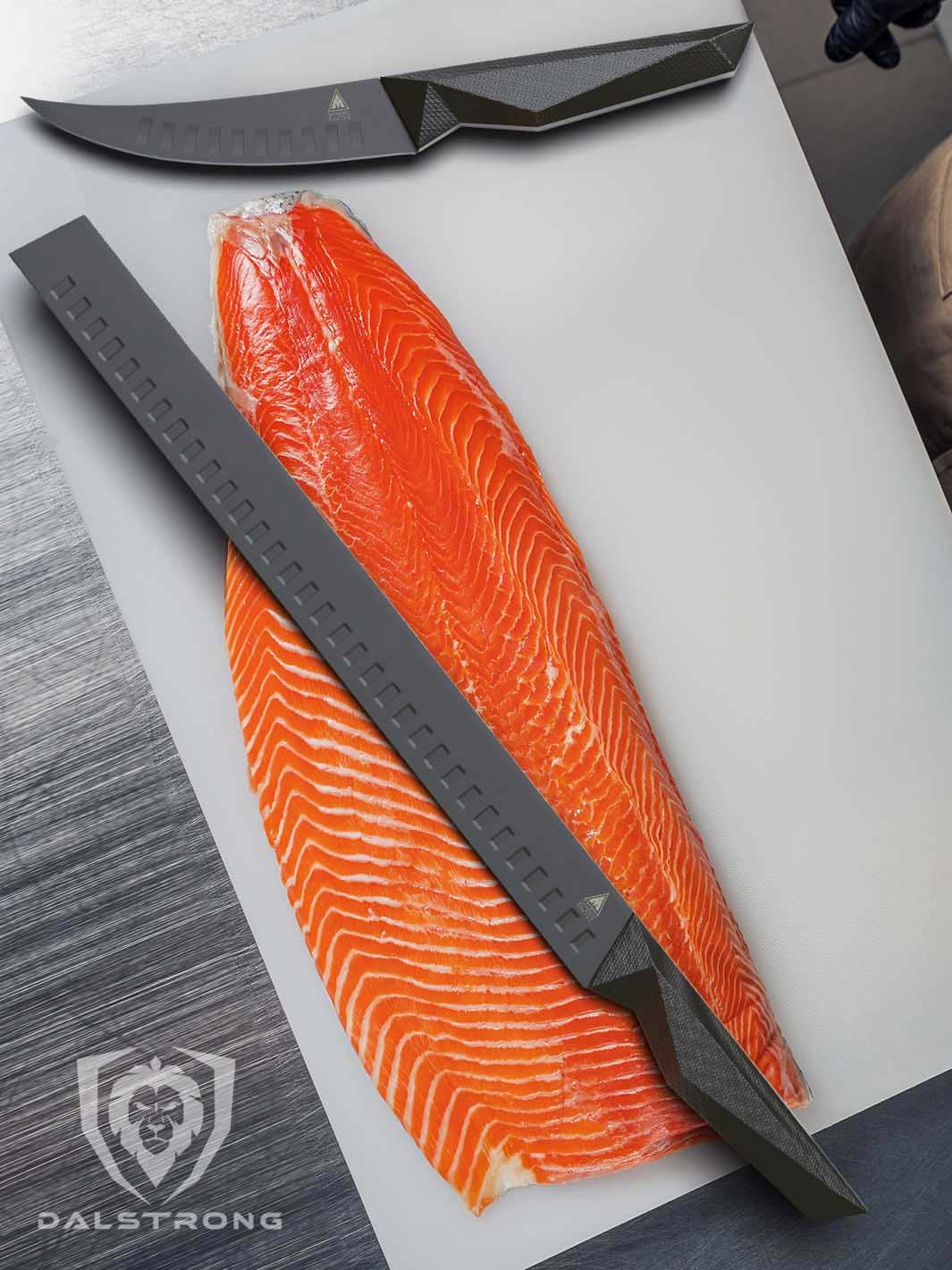 Dalstrong shadow black series 14 inch slicer knife with a fillet of salmon on a white board.