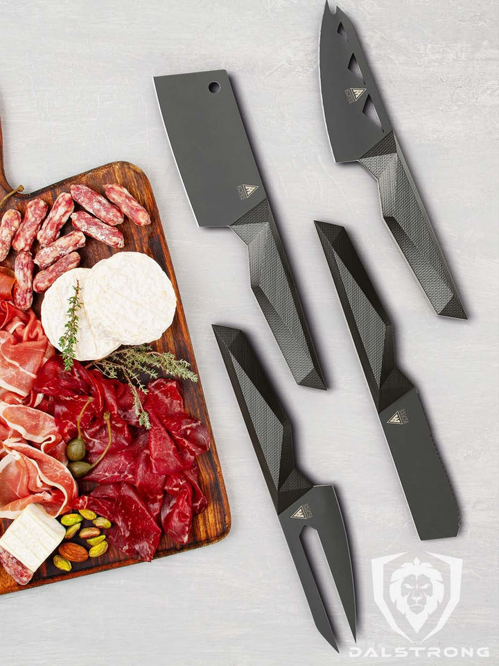 Dalstrong shadow black series 4 piece cheese knife set with different kinds of meat and cheese on a cutting board.