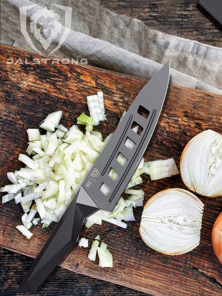 Dalstrong shadow black series 7 inch vegetable knife with chopped onions on a wooden board.