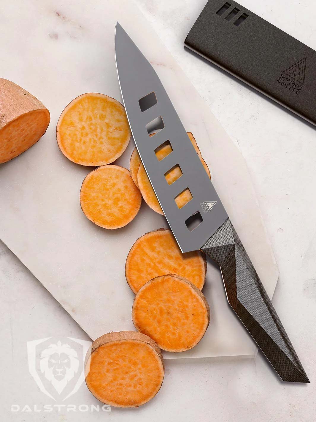 Dalstrong shadow black series 7 inch vegetable knife and black sheath beside slices of sweet potatoes.