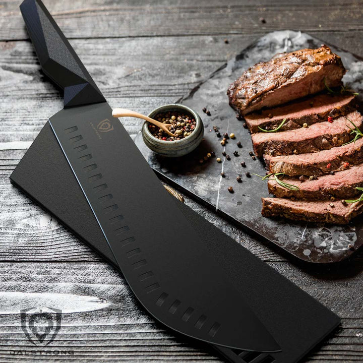 Dalstrong shadow black series 10 inch bull nose butcher knife with black sheath beside slices of steam on a cutting board.