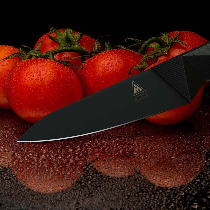 Dalstrong shadow black series 4 inch paring knife with six red tomatoes on the side.