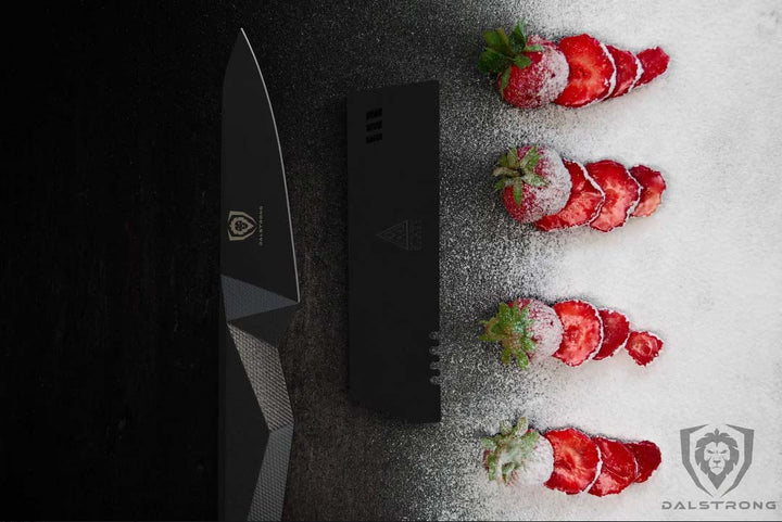 Dalstrong shadow black series 4 inch paring knife with thin slices of stawberries on the side.