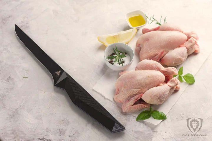 Dalstrong shadow black series 6 inch straight boning knife with two whole chicken at the side.