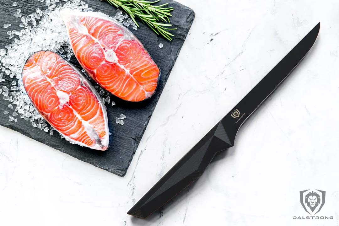 Dalstrong shadow black series 6 inch straight boning knife with two fillets of salmon on the side.