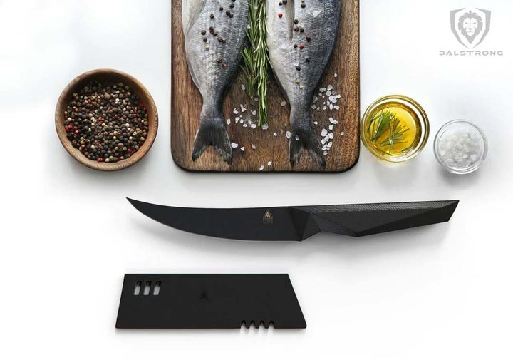 Dalstrong shadow black series 6 inch fillet knife with black sheath and two whole fish on a cutting board.