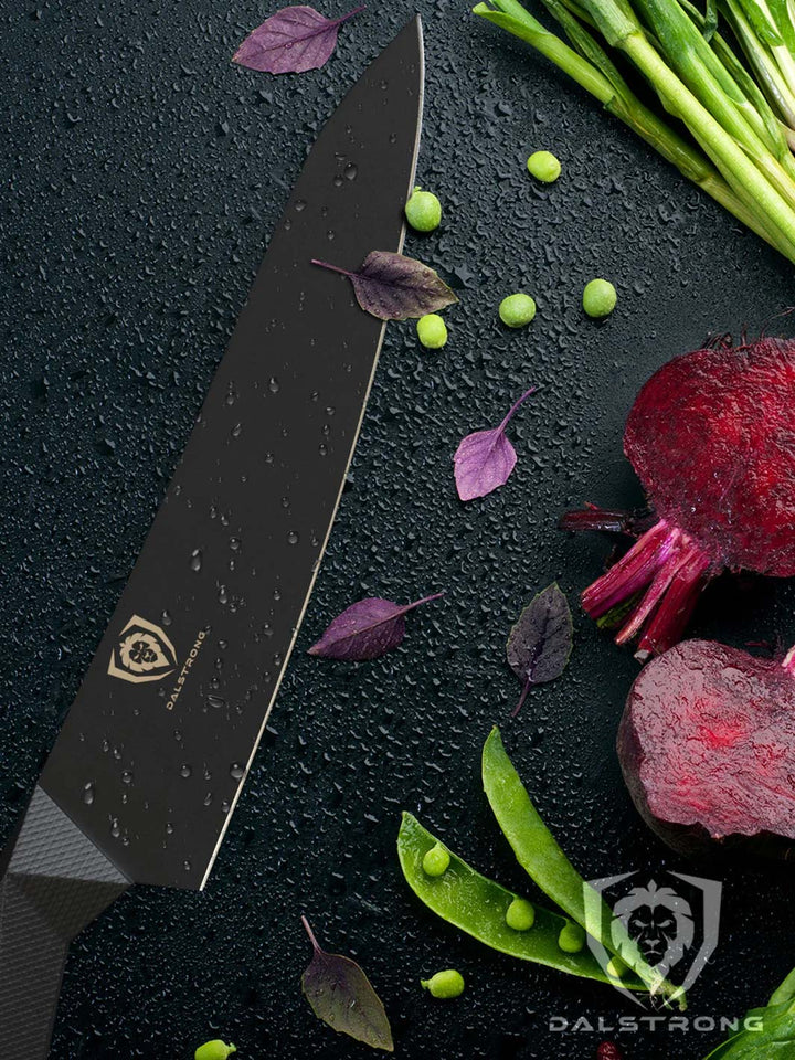 Dalstrong shadow black series 8 inch chef knife with green vegetables on the side.
