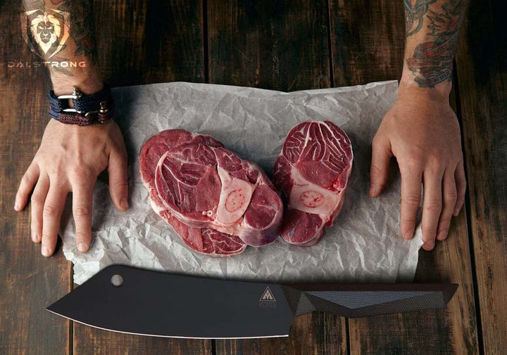 Dalstrong shadow black series 8 inch crixus cleaver knife with three cuts of meat on a wooden table.