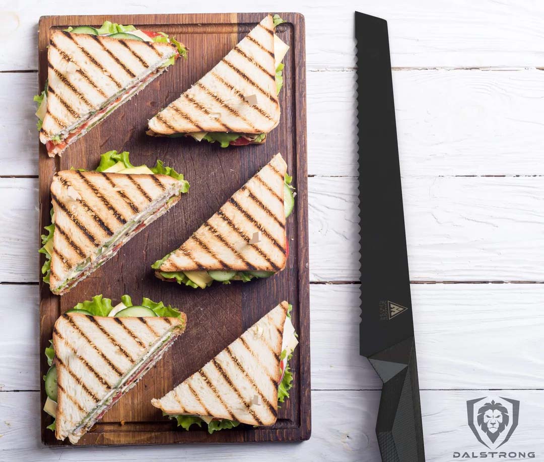 Dalstrong shadow black series 9 inch bread knife with six sandwiches on a cutting board.