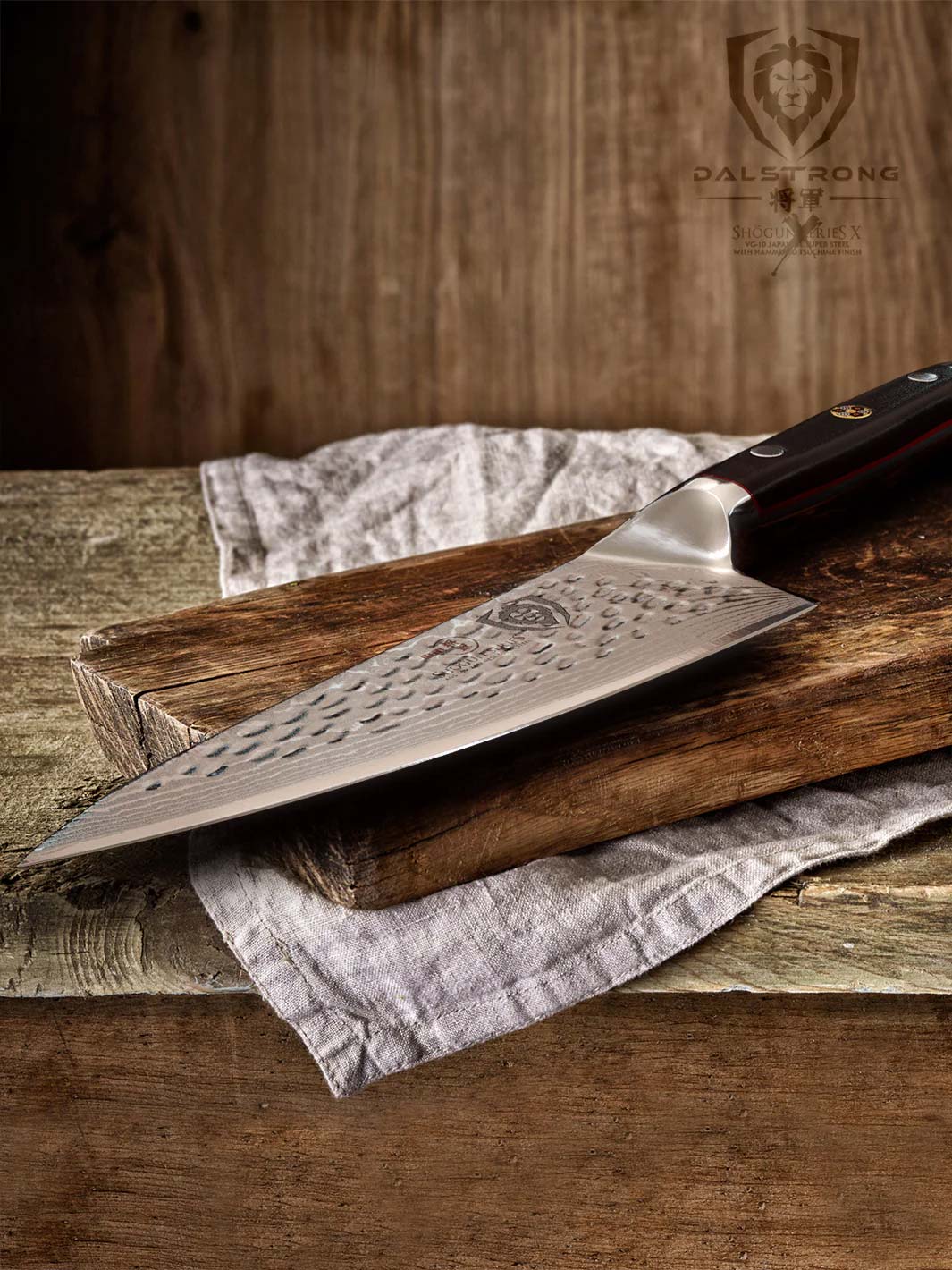 Dalstrong shogun series 6 inch chef knife with black handle on top of a wooden board.