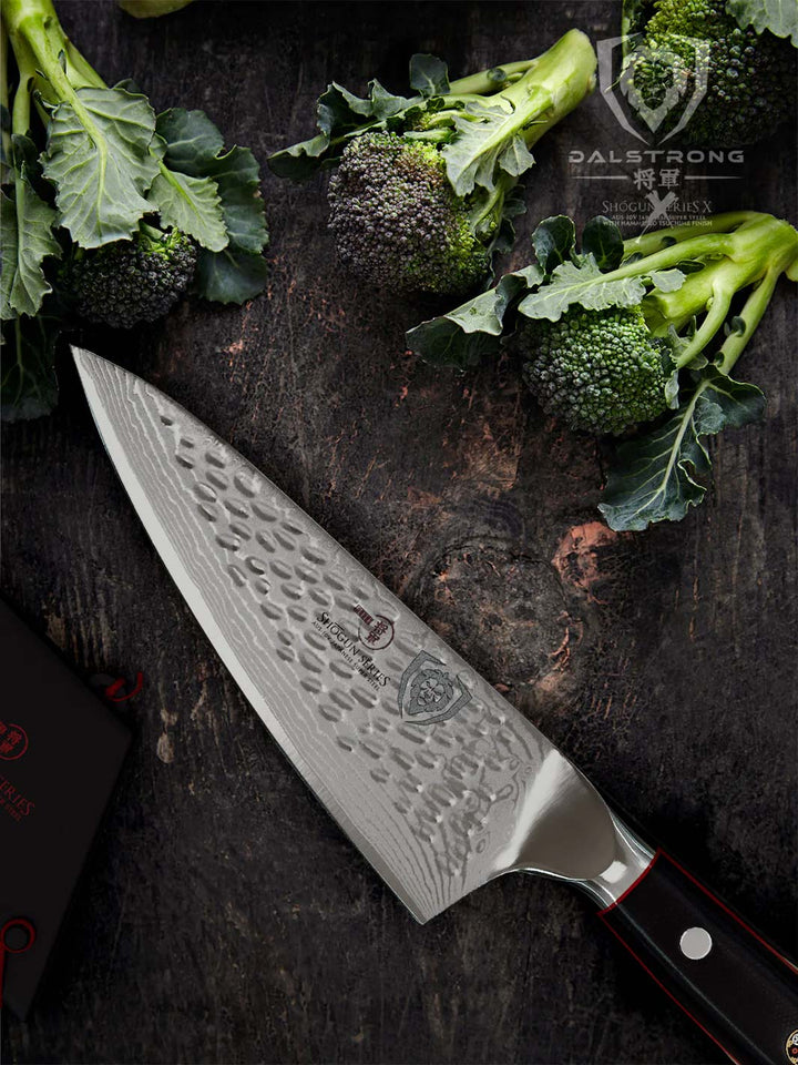 Dalstrong shogun series 6 inch chef knife with black handle and four broccoli at the top.