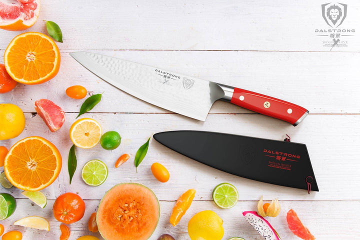 Dalstrong shogun series 8 inch chef knife with crimson red handle and slices of different fruits.