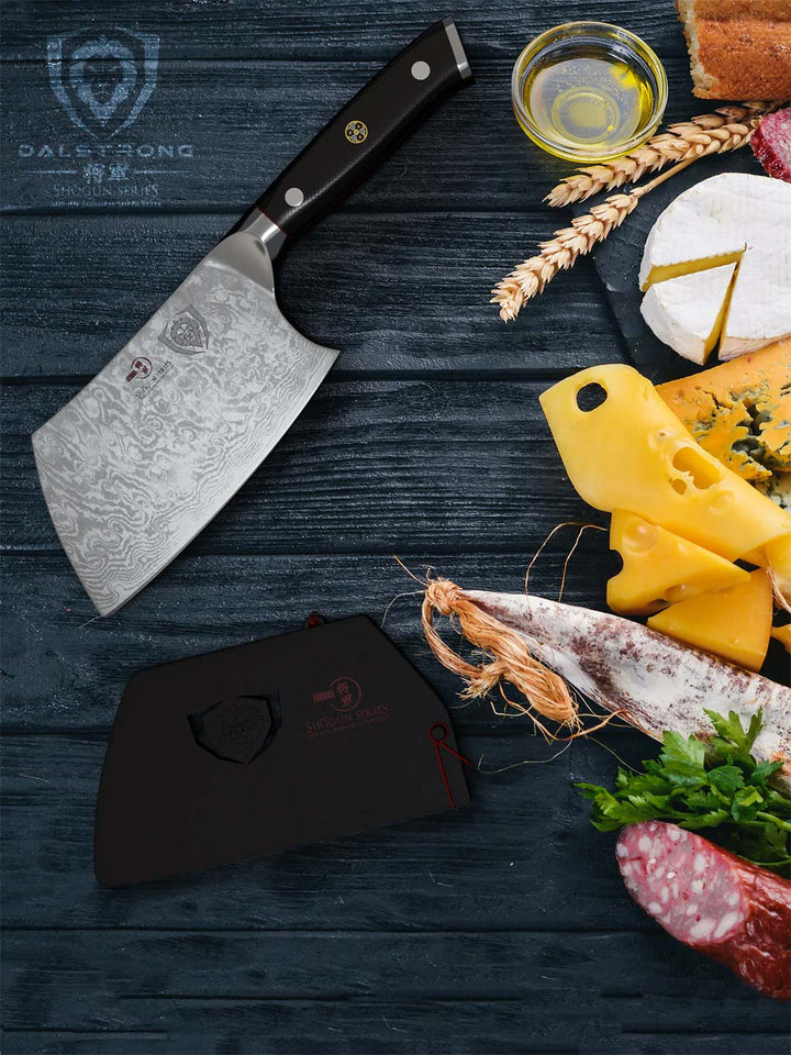 Dalstrong shogun series 4.5 inch mini cleaver knife with black handle and cheese beside it on a wooden table.