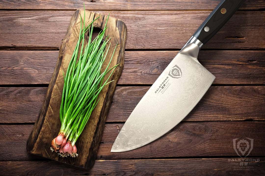 Dalstrong shogun series 7 inch rocker cleaver knife with black handle and scallions on a wooden board.
