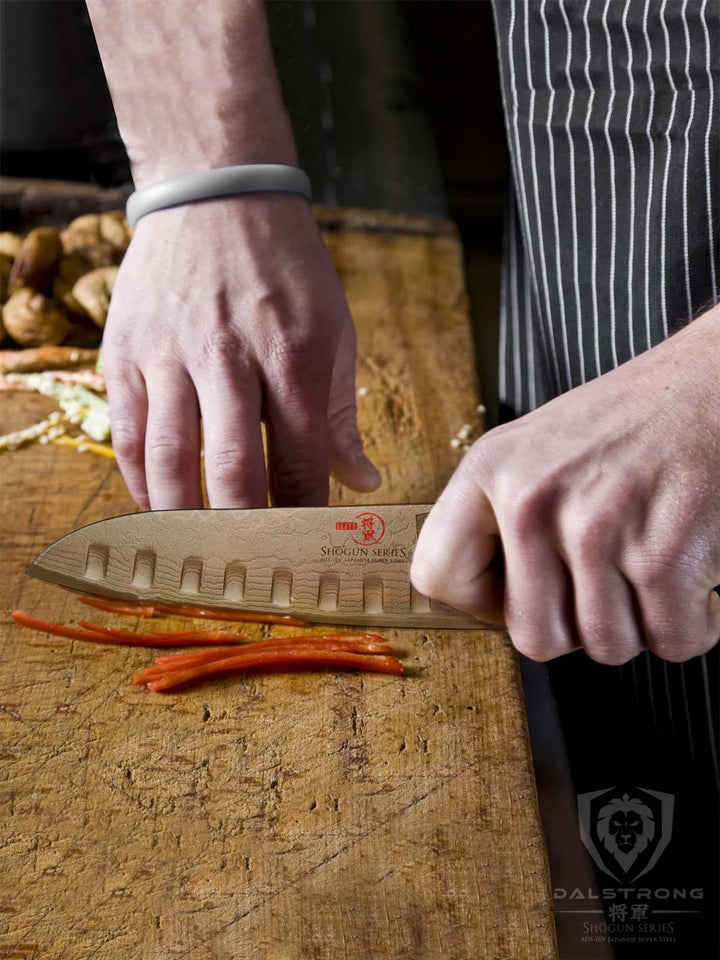 Dalstrong shogun series 7 inch santoku knife slicing a bell pepper on a wooden board.
