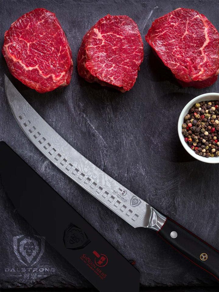 Dalstrong shogun series 8 inch butcher knife with black handle and sheath under three cuts of meat.