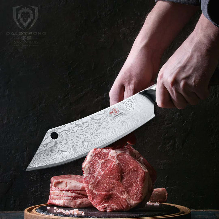 Dasltrong shogun series 8 inch crixus cleaver knife with black handle and two large cuts of meat.