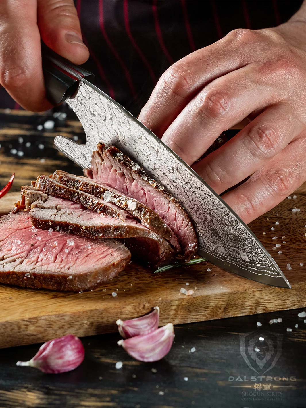 Dalstrong shogun series 8 inch guardian chef knife slicing through a steak on a wooden board.