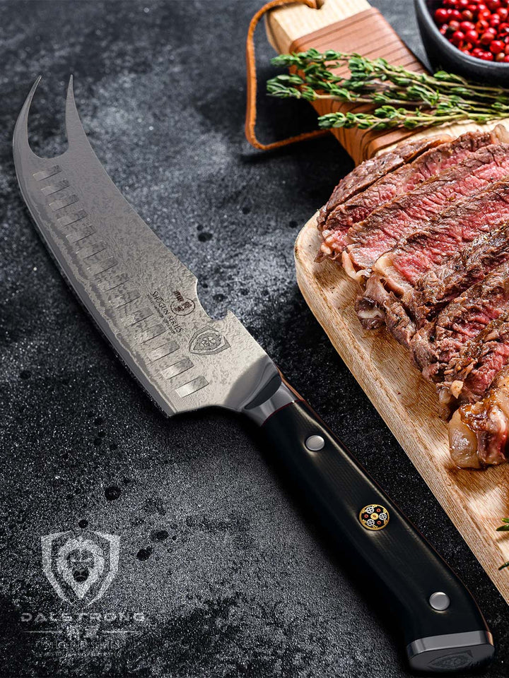 Dalstrong shogun series 8 inch pitmaster knife with black handle and sliced steaks on top of a wooden board.