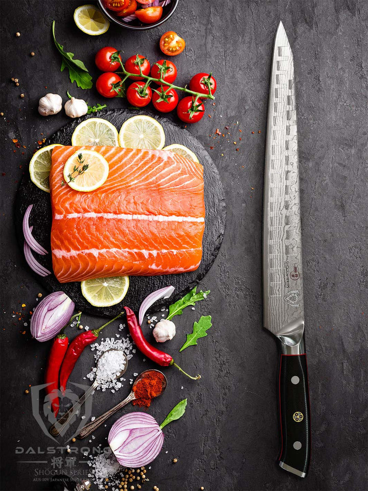 Dalstrong shogun series 10.5 inch sujihiki slicing knife with a black handle and a fillet of salmon beside it.