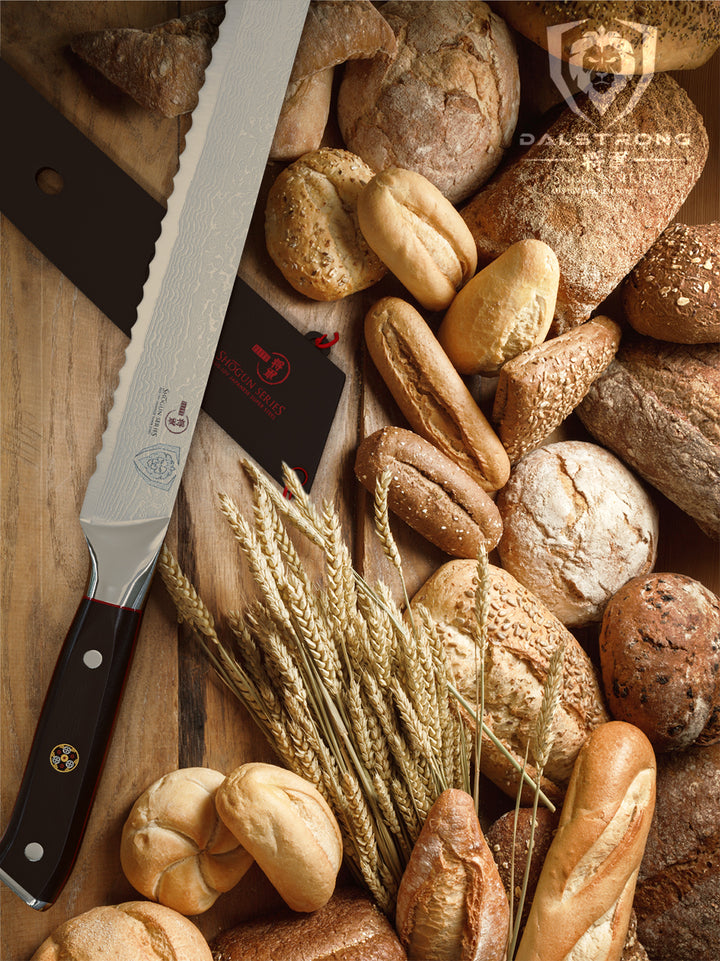 Dalstrong shogun series 10.25 inch bread knife with black sheath and different kinds of bread around it.