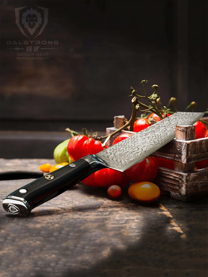 Dalstrong shogun series 8.5 inch kiritsuke knife with black handle and tomatoes inside of a box.