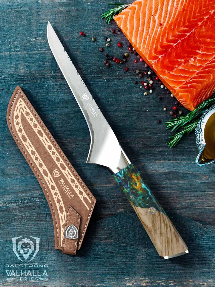 Dalstrong valhalla series boning knife with wooden handle and sheath beside a fillet of fish.