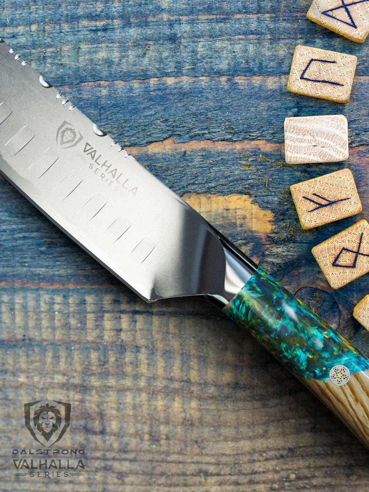 Dalstrong valhalla series 7 inch santoku knife with wooden handle on top of a wooden table.