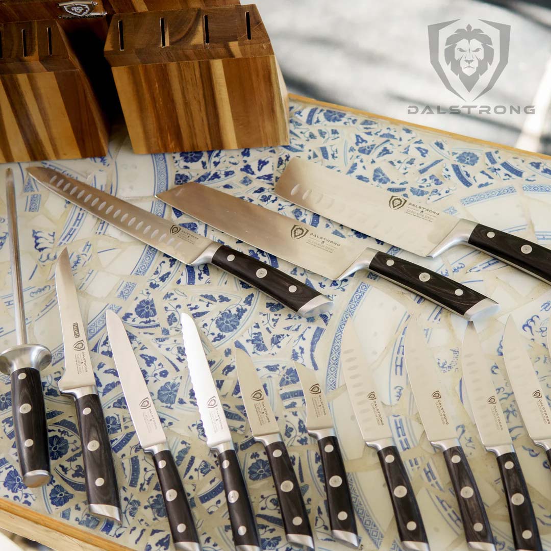 Dalstrong gladiator series 18 piece knife set with black handes and block laid down on a wooden table.