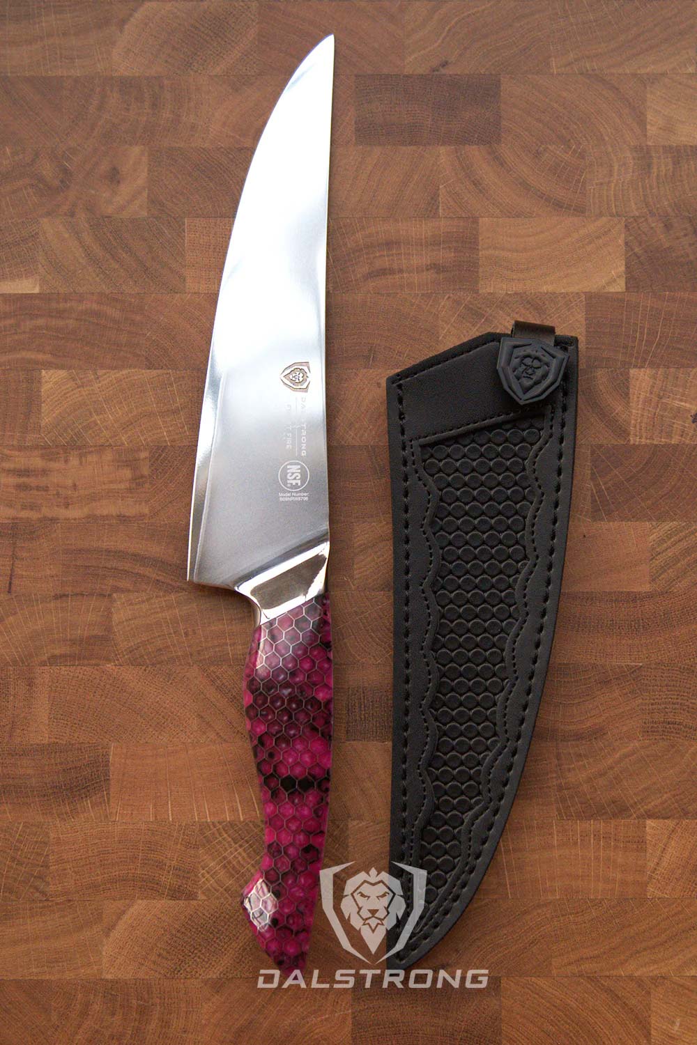 Dalstrong frost fire series 8 inch chef knife with fuchsia handle and black sheath on top of a wooden board.