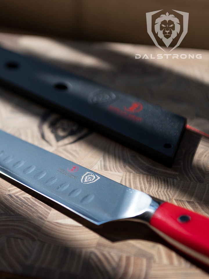 Dalstrong shogun series 12 inch slicer knife with crimson red handle and black sheath on a wooden Dalstrong board.