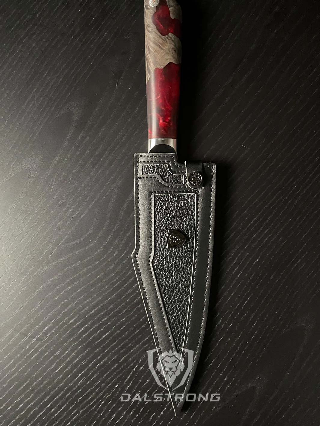 Dalstrong spartan ghost series 7 inch santoku knife inside it's black sheath.