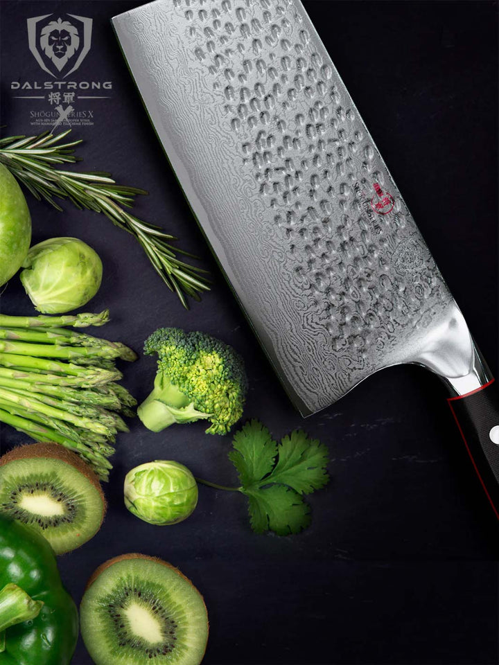 Dalstrong shogun series 7 inch cleaver knife with black handle and a chopped kiwi in half.