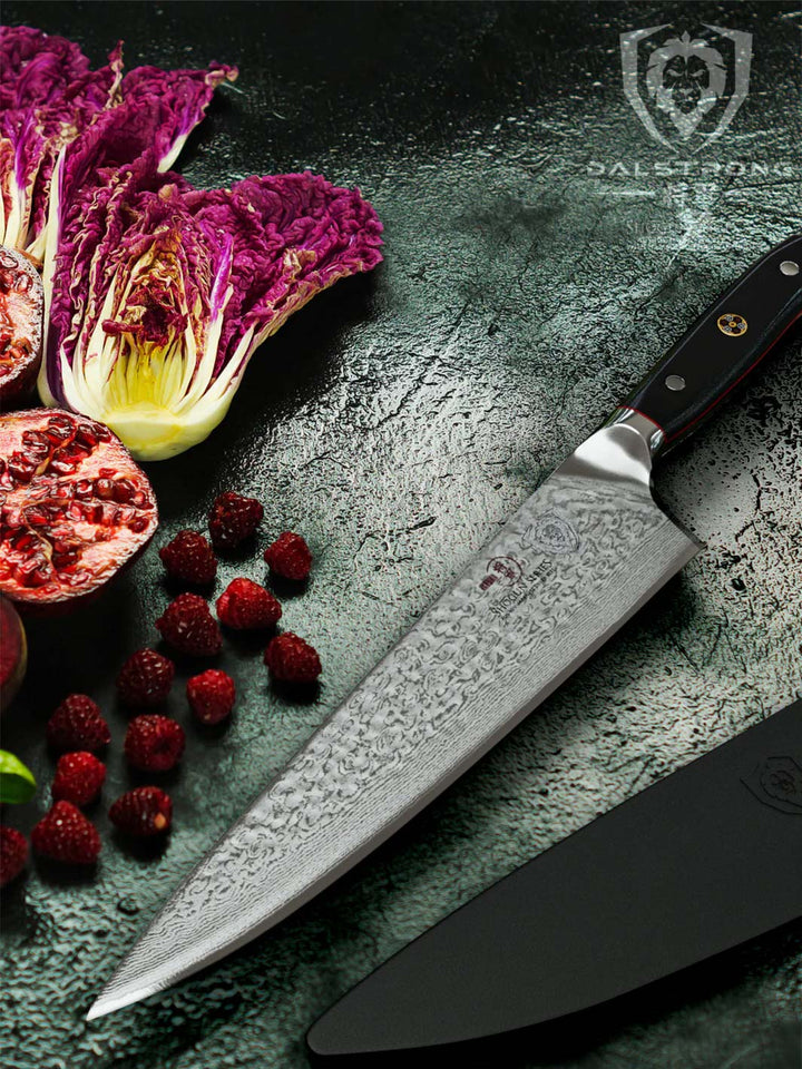 Dalstrong shogun series 10.25 inch chef knife with black handle and sliced red chinese cabbage on the side.