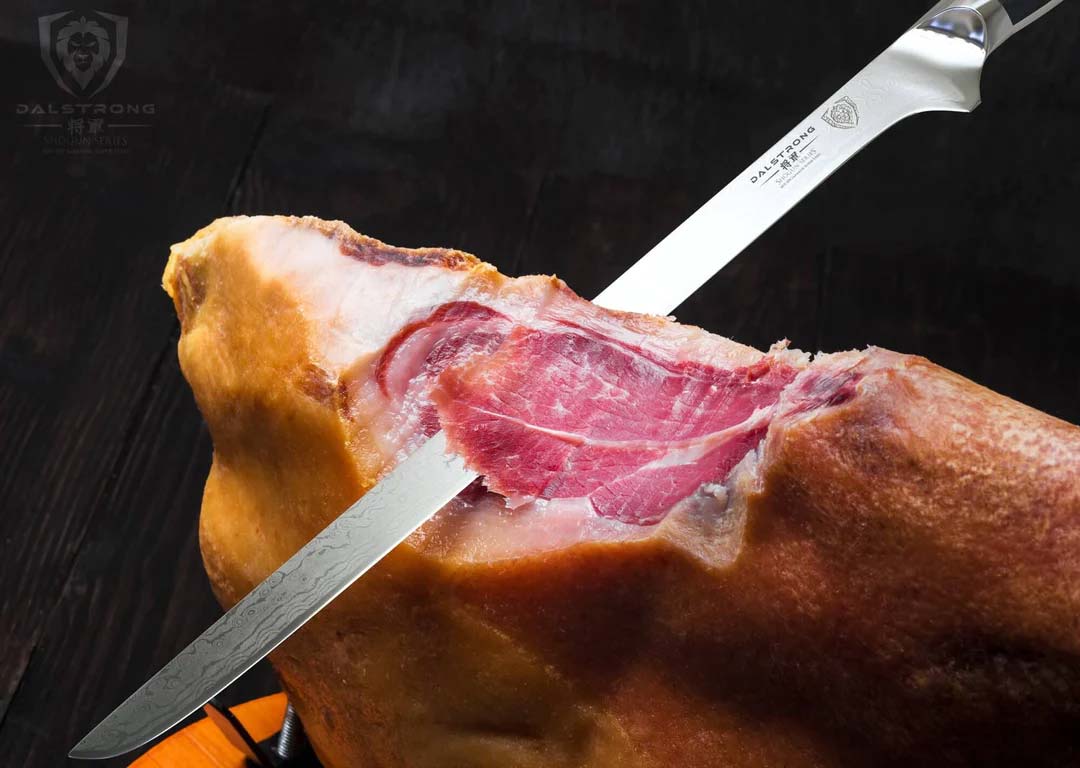 Dalstrong shogun series 12 inch spanish slicer knife slicing a huge ham leg.