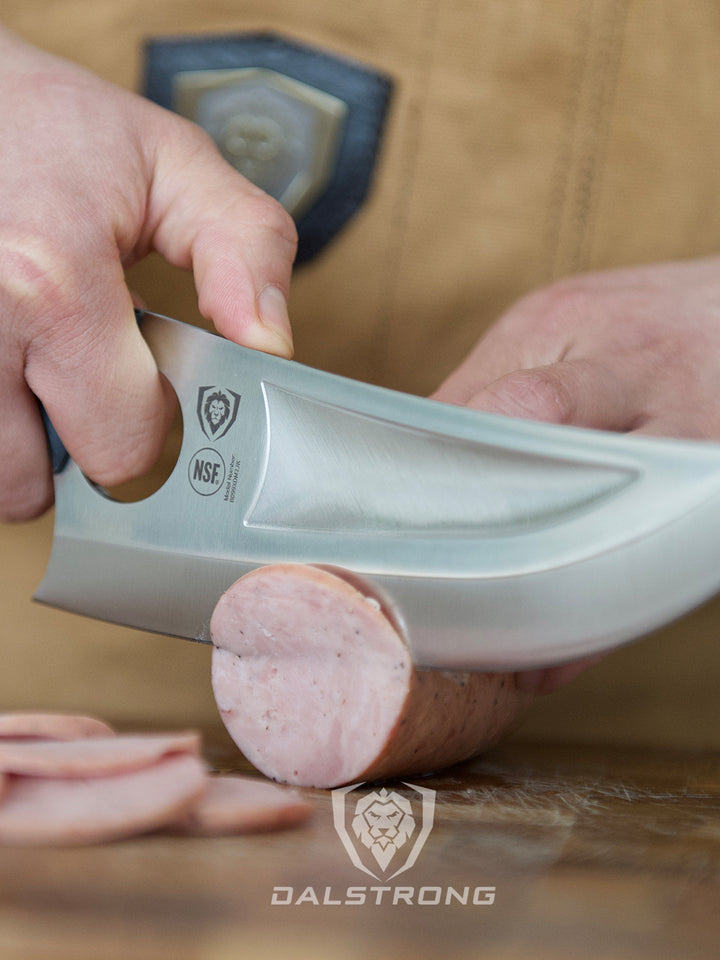 A man slicing a sausage using the dalstrong gladiator series 7 inch venator knife with black handle on a wooden cutting board.